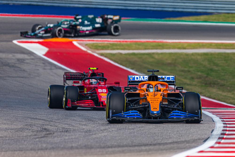 Formula 1 racers in a hairpin turn, illustrating international group travel packages for sports and events.